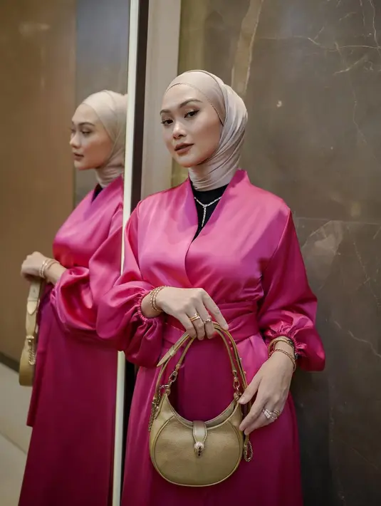 <p>Nuansa pink selalu memberikan kesan glamor saat dipakai. Untuk mengimbangi nuansa meriha, selaraskan dengan hijab warna lembut agar jadi satu kesatuan yang tetap terlihat elegan. (Foto: Indahnadapuspita/ Instagram)</p>