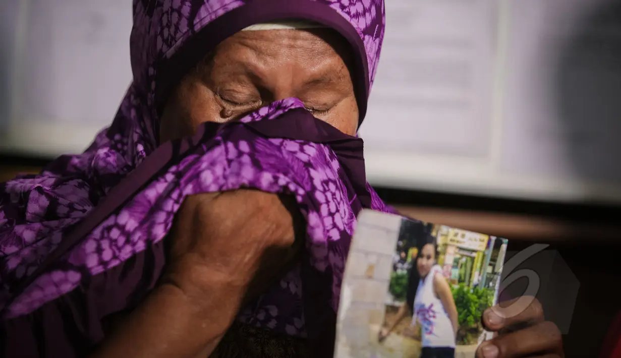 Narsiah, ibu kandung Wanipah menunjukan foto anaknya, di sekretariat SPILN, Jakarta, Minggu (17/5). Narsiah menyampaikan permohonan bantuan kepada Presiden Jokowi terkait ancaman hukuman mati TKI Wanipah. (Liputan6.com/Faizal Fanani)