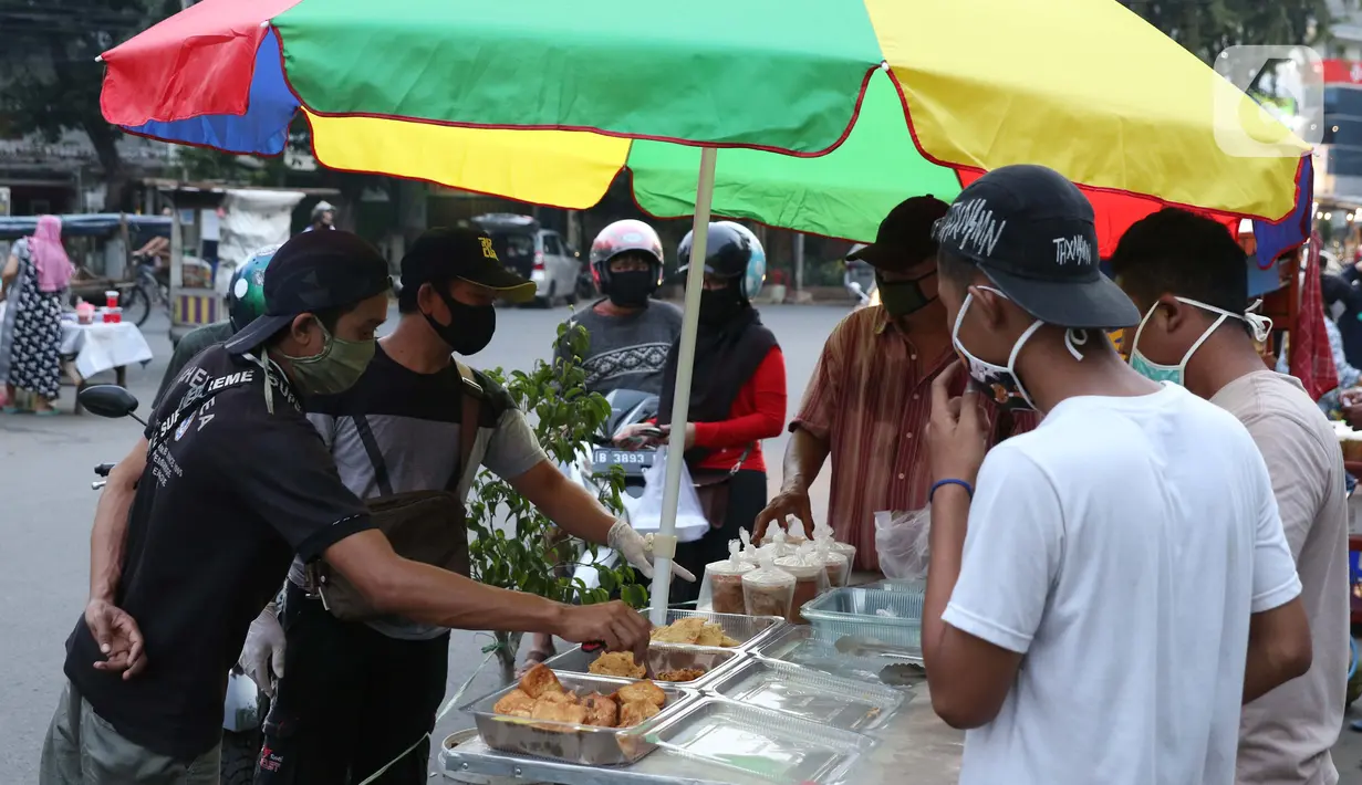 Aktivitas jual beli makanan untuk berbuka puasa di kawasan Bendungan Hilir, Jakarta, Sabtu (25/4/2020). Meski ditengah pandemi virus Covid-19, masyarakat masih antusias berburu penganan berbuka puasa dengan tetap menerapkan pola jaga jarak dan memakai masker. (Liputan6.com/Helmi Fithriansyah)
