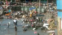 Orang-orang memeriksa kerusakan akibat gempa bumi dan tsunami yang melanda Kota Palu, Sulawesi Tengah, Minggu (30/9). Dampak dari bencana tersebut melulunlantakkan bangunan dan ratusan jiwa meninggal dunia. (AP Photo/Tatan Syuflana)
