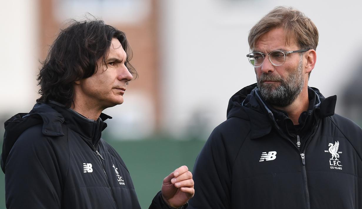 Pelatih Liverpool, Jurgen Klopp (kanan) berdiskusi dengan asisten pelatih, Zeljko Buvac saat sesi latihan di Melwood Training Ground, Liverpool, (3/4/2018). Liverpool akan menjamu Manchester City pada leg pertama Liga Champions. (AFP/Paul Ellis)