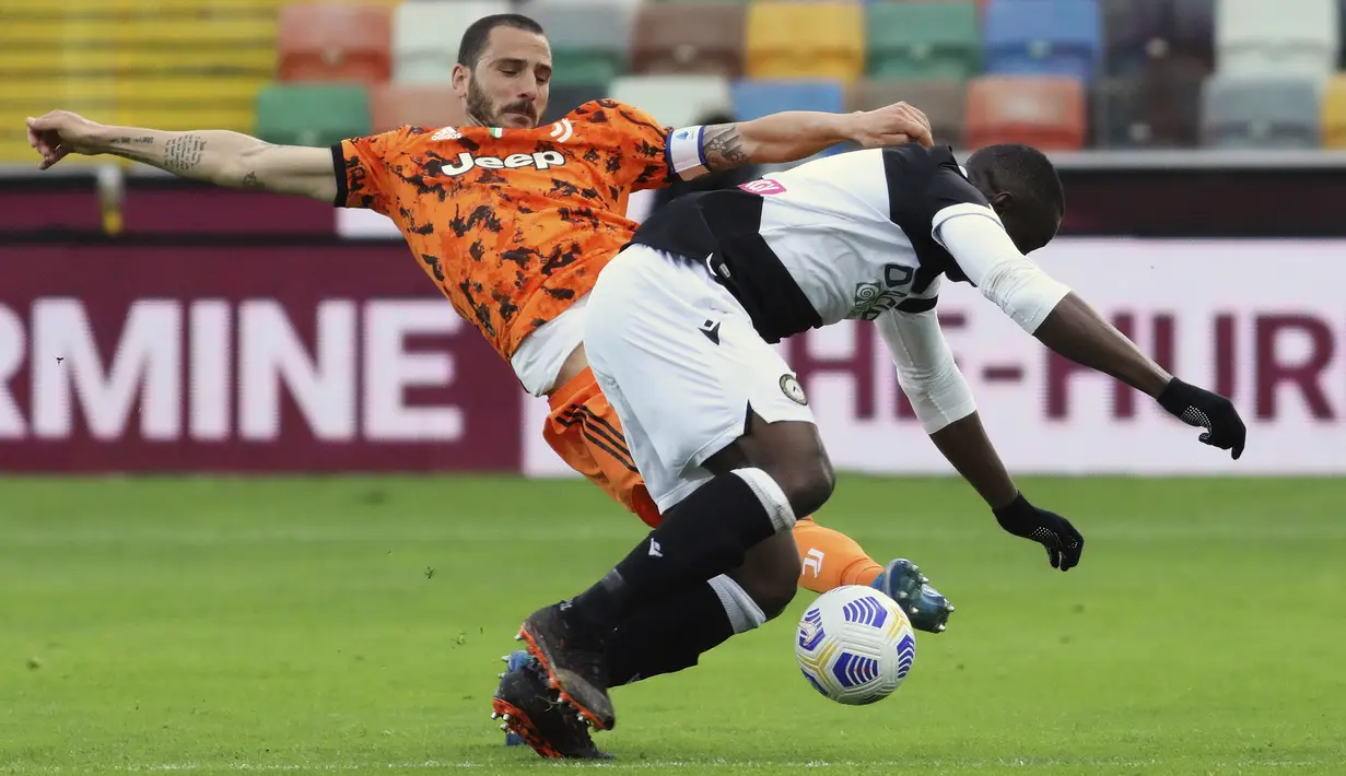 Bek Juventus, Leonardo Bonucci berusaha merebut bola dari pemain Udinese, Stefano Okaka pada pertandingan Liga Italia di di stadion Dacia Arena di Udine, Italia, Senin (3/5/2021). Juventus menang tipis atas Udinese 2-1. (Andrea Bressanutti/LaPresse via AP)