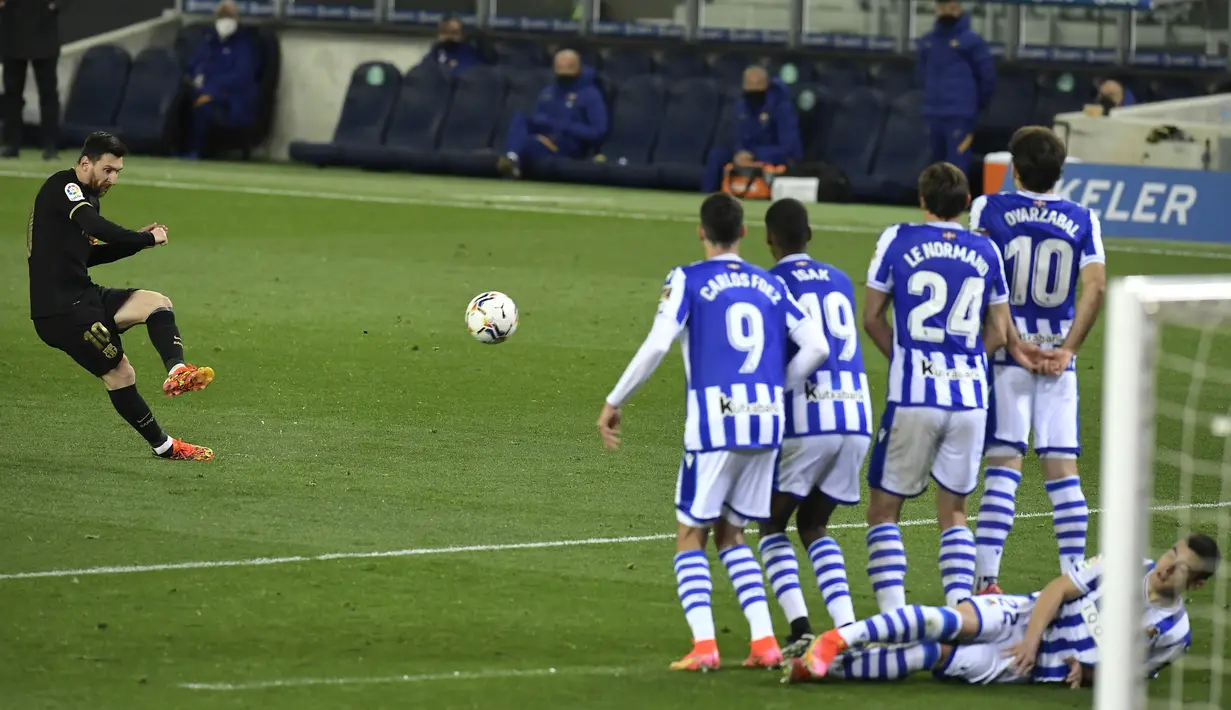 Penyerang Barcelona, Lionel Messi melakukan tendangan bebas saat melawan Real Sociedad pada pertandingan La Liga Spanyol di stadion Reale Arena, Spanyol (22/3/2021). Atas hasil ini, Lionel Messi dkk pun menggusur Real Madrid dari peringkat kedua klasemen. (AP Photo/Alvaro Barrientos)