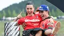Pembalap Ducati Lenovo, Marc Marquez, bersama kekasihnya, Gemma Pinto, merayakan keberhasilan menjuarai MotoGP 2025 di Sirkuit Motegi, Jepang, Minggu (28/09/2025). (AFP/Toshifumi Kitamura)
