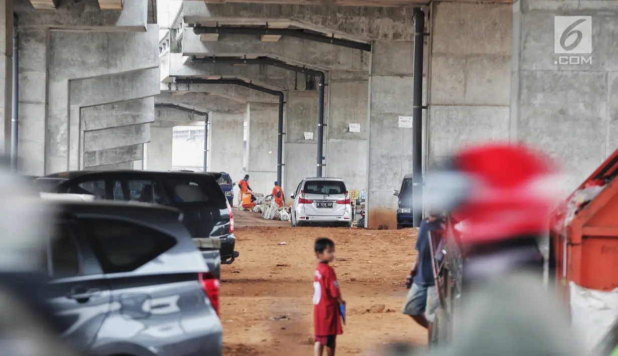 Petugas kebersihan beraktivas dekat sejumlah mobil yang terparkir di bawah kolong tol Becakayu Kalimalang, Jakarta Timur, Selasa (12/2). Lahan kosong di bawah kolong tol Becakayu disalahgunakan menjadi parkir liar. (Liputan6.com/Faizal Fanani)