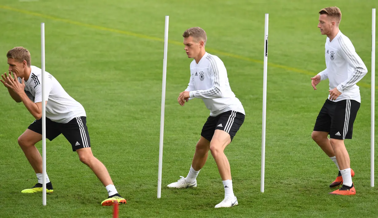 Gelandang Jerman Nils Petersen, Marco Reus dan bek Matthias Ginter melakukan pemanasan selama sesi pelatihan tim di Munich, Jerman Selatan, (4/9). Jerman akan menghadapi Prancis di UEFA Nations League pada 6 September 2018. (AFP Photo/Christof Stache)