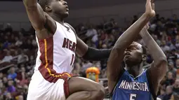 Aksi pemain Miami Heat, Dion Waiters melakukan layup melewati hadangan pemain Minnesota Timberwolves, Gorgui Dieng #5  pada laga NBA preseason basketball game di Louisville, (15/10/2016). (AP/Timothy D. Easley)