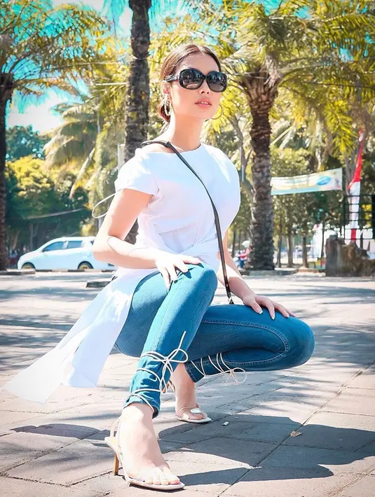 Begini gaya perwakilan Miss Universe Indonesia 2019 saat berkunjung ke alun-alun Jember. Frederika tampil cantik dengan basic Sleeveless dipadukan dengan celana jeans dan high heels. Ia juga cantik dengan aksesoris minimalis seperti kacamata dan sling bag.(Liputan6.com/IG/@frederikacull)