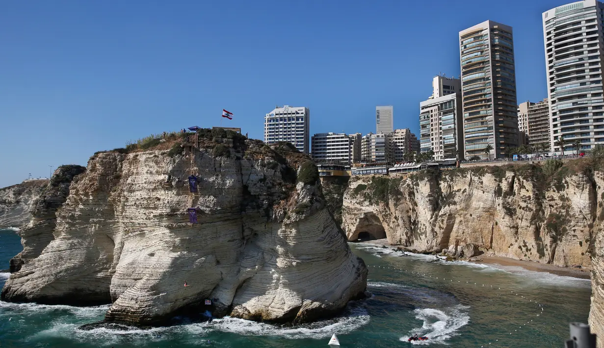 Aksi peserta melompat dari batu karang laut 'Raouche' dalam kompetisi Red Bull Cliff Diving World Series di Beirut, Lebanon, 14 Juli 2019. Sebanyak 40 atlet terdiri dari 10 wanita dan 14 pria yang berasal dari 18 negara melakukan lompatan dari ketinggian 21 - 27 meter. (AP/Hussein Malla)