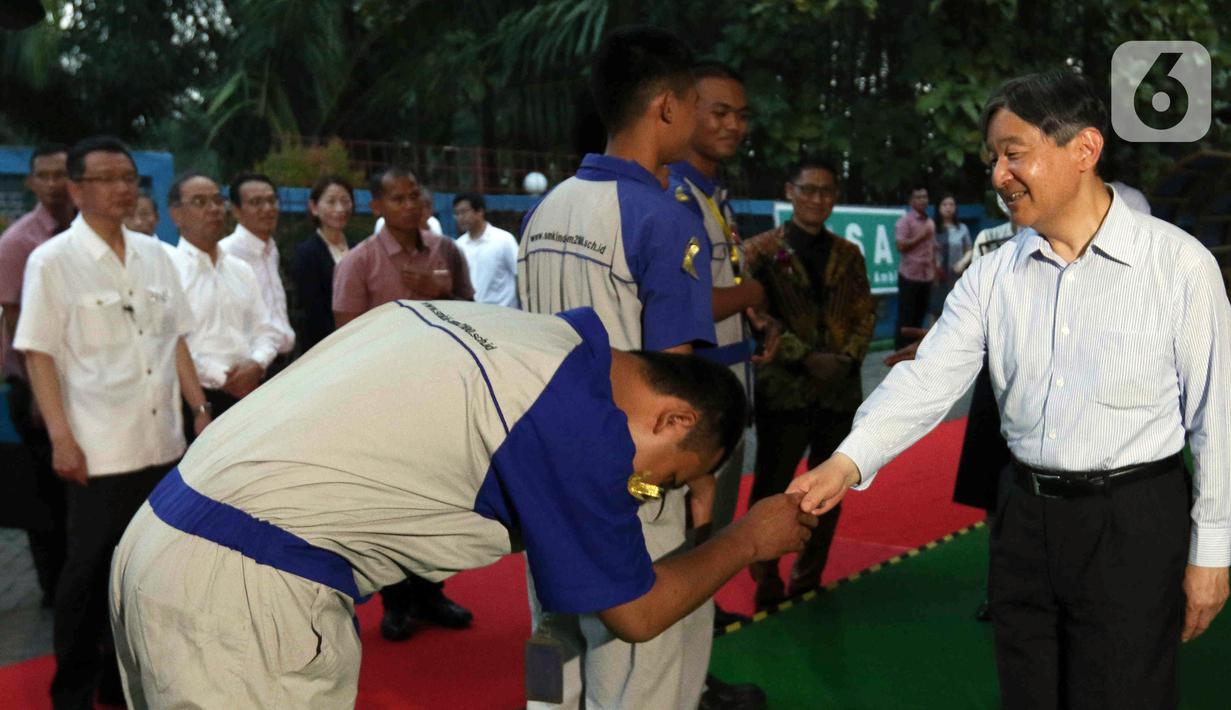 Kaisar Jepang Naruhito (kanan) menyalami siswa saat mengunjungi Sekolah Menengah Kejuruan (SMK) Mitra Industri M2100 di Cikarang, Kabupaten Bekasi, Jawa Barat, Selasa (20/6/2023). SMK Mitra Industri M2100 merupakan sekolah yang didirikan dan dikelola oleh perusahaan Jepang. (Liputan6.com/Herman Zakharia)
