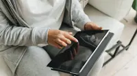Ilustrasi seorang wanita sedang mematikan tablet. © (Polina Tankilevitch/ pexels.com)