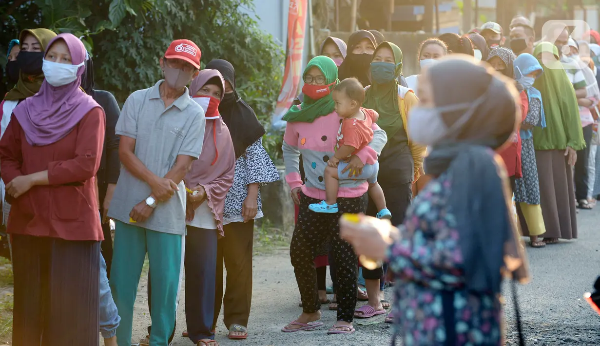 Antrean warga sekitar perumahan Villa Pamulang mengambil paket sembako gratis bernama “Jumat Berkah” yang digantung di Tangerang Selatan, Jumat (28/8/2020). Setiap Jumat selama pandemi, warga perumahan itu mendonasikan sembako untuk warga sekitar yang terdampak COVID-19. (merdeka.com/Dwi Narwoko)
