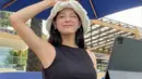 Membaca dan mendengarkan musik, Kim Se Jeong begiut menikmati cuaca cerah di tepi pantai itu. Ia tampak mengenakan crop top hitam. (Instagram/clean_0828)