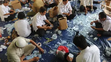 Pegawai  Negeri Sipil (PNS) di lingkungan Kemendagri menggunting E-KTP untuk dihancurkan di Gundang Kemendagri, Bogor (30/5). Sekitar seratus PNS dilibatkan selama sepuluh hari untuk menghancurkan lebih dari 800 ribu E-KTP. (Merdeka.com/Arie Basuki)