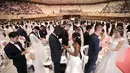Pasangan pengantin bertukar cincin dalam pernikahan massal di Cheong Shim Peace World Center, Gapyeong, Korea Selatan, Senin (27/8). Acara ini diikuti sekitar 3.800 pasangan pengantin. (AP Photo/Ahn Young-joon)