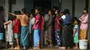 Warga yang mengungsi sementara akibat banjir mengantre makanan di sebuah sekolah yang digunakan sebagai tempat pengungsian di Taungoo, wilayah Bago, Myanmar, pada tanggal 12 September 2024. (Sai Aung MAIN/AFP)