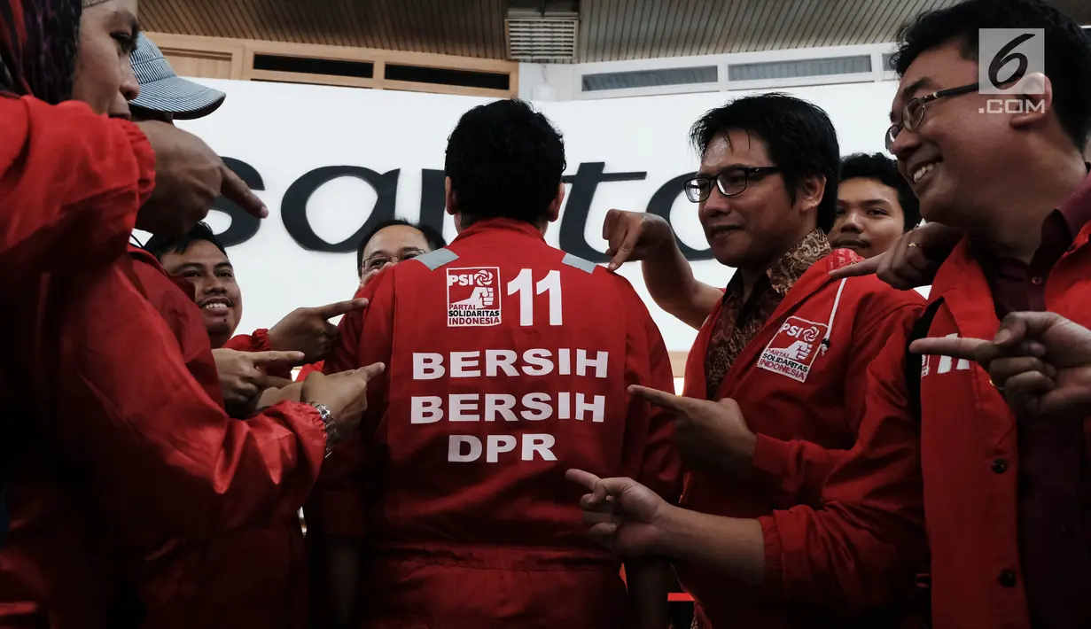 Calon legislatif dari Partai Solidaritas Indonesia (PSI) mendatangi gedung DPR RI di Senayan, Jakarta, Jumat (7/12). Kedatangan mereka untuk kampanye bersih-bersih DPR sambil mengenakan seragam merah ala cleaning service. (Liputan6.com/Johan Tallo)