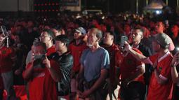 Para suporter Indonesia ikut berdiri menyanyikan lagu kebangsaan Indonesia Raya saat acara nonton bareng laga perebutan tempat ketiga Piala Asia U-23 2024 antara Timnas Indonesia U-23 menghadapi Irak di Plaza Kemenpora, Senayan, Jakarta Pusat, Kamis (2/5/2024) malam WIB. (Bola.com/Afi)