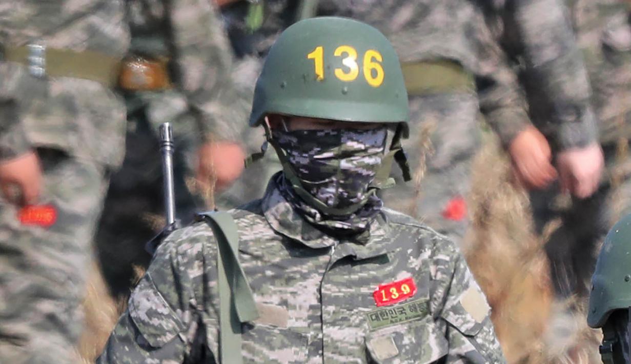 Pemain Tottenham Hotspur, Son Heung-min, berseragam militer lengkap dengan senjata saat mengikuti wajib militer di Korsel, (6/5/2020). Penundaan Premier League karena virus corona dimanfaatkan Son Heung-min untuk mengikuti program wajib militer. (AFP/STR)