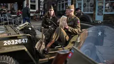 Reenactor Perang Dunia II mengenakan pakaian tentara duduk diatas Jip saat mengikuti 'Railway in Wartime Event' yang ke 25 di Pickering, Inggris (15/10). Reenactor adalah para penggiat sejarah yang mirip dengan cosplayer. (AFP Photo/Oli Scarff)