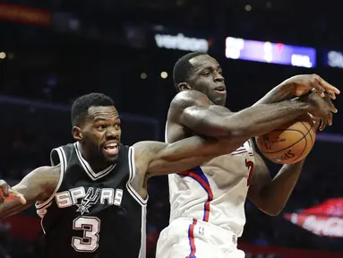 Pemain Los Angeles Clippers, Brandon Bass (kanan) berebut bola dengan pemain,  San Antonio Spurs, Dewayne Dedmon pada laga NBA basketball game di Staples Center, (22/12/2016). Clippers menang 106-101. (AP/Jae C. Hong)