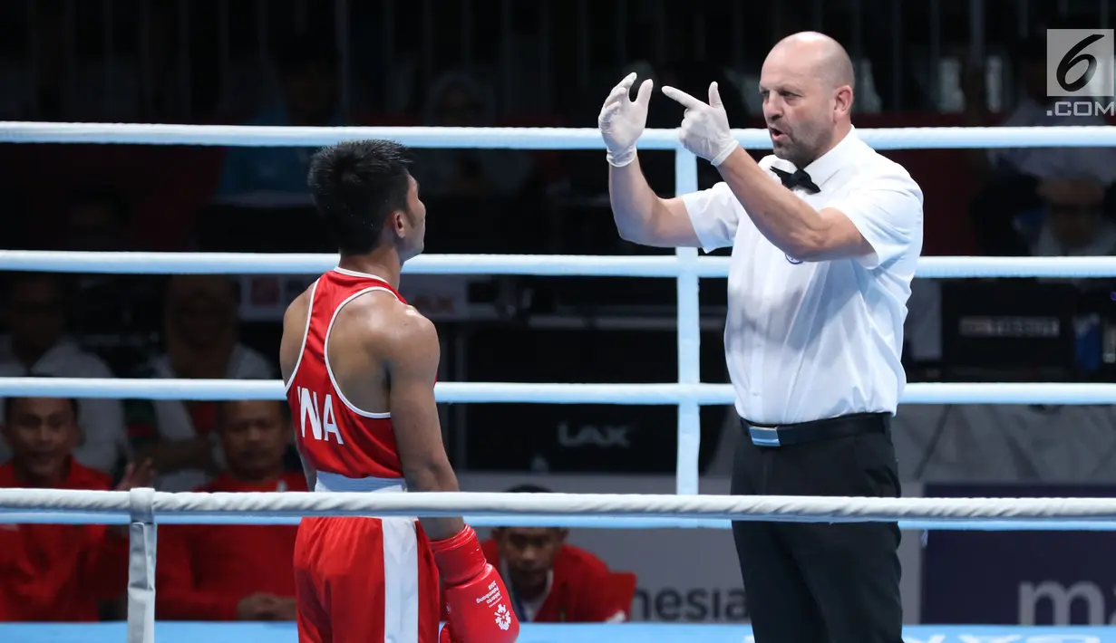 Petinju Indonesia, Sunan Agung Amoragam (kaus merah) mendapat hitungan dari wasit saat melawan Mirazizbek Mirzakhalilov (Uzbekistan) pada semifinal bantam 56kg putra Asian Games 2018 di JIEXPO Kemayoran, Jumat (31/8). (Liputan6.com/Helmi Fithriansyah)