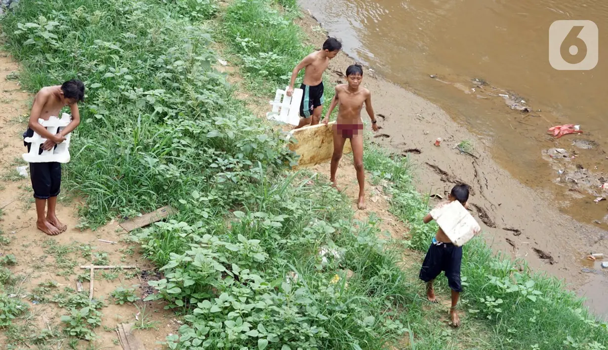 Anak-anak berjalan di pnggir Sungai Ciliwung, Jatinegara, Jakarta Timur, Sabtu (4/7/2020). Minimnya lahan bermain menyebabkan anak-anak tersebut bermain tidak pada tempatnya, meski dapat membahayakan keselamatan. (Liputan6.com/Immanuel Antonius)