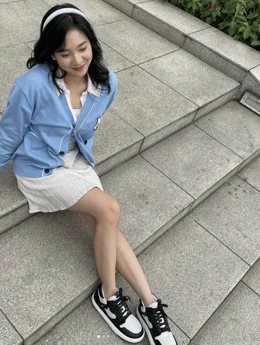 Paduan mini skirt dan cardigan dengan nuansa cerah dan sneakers juga akan wujudkan tampilan bergaya school girl. [Foto: Instagram/ Zee JKT48]