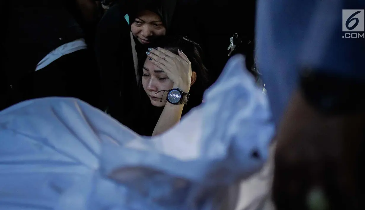 Kekasih almarhum Andika Putra Sahadewa, Nicky Santoso menangis di dekat makam di TPU Sunan Giri, Rawamangun, Jakarta, Selasa (10/9). Bassist grup band Kerispatih, Andika Putra Sahadewa, meninggal dunia di usia 36 tahun. (Liputan6.com/Faizal Fanani)
