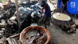 Pekerja mengaduk adonan untuk membuat dodol Betawi di kawasan Studio Alam TVRI, Cilodong, Depok (31/5). Proses pencampuran antara gula dengan beras ini membutuhkan waktu hingga sekitar tujuh jam. (Merdeka.com/Arie Basuki)