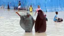 Wanita Somalia berjalan melewati air banjir saat hujan lebat di Mogadishu, Somalia, 20 November 2023. Banjir terburuk yang melanda Somalia dalam beberapa dekade telah menewaskan banyak orang dan memaksa ribuan orang meninggalkan rumah mereka. (AP Photo/Farah Abdi Warsameh)