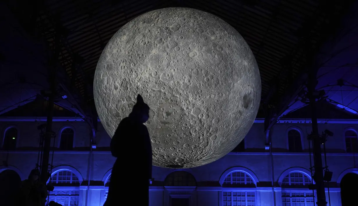 Seorang pria melewati pertunjukan cahaya malam di Lyon, Prancis tengah, Rabu (8/12/2021). Jutaan orang diperkirakan akan menghadiri acara Festival of Lights selama empat hari di kota itu. (AP Photo/Laurent Cipriani)