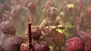 Sejumlah pria India bernyanyi dan bermain musik dengan tubuh berlumuran warna saat mengikuti festival Holi di desa Nandgaon di negara bagian Uttar Pradesh, India (7/3). (AFP)