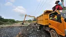 Petugas dari Dinas Lingkungan Hidup Kabupaten Bekasi menggunakan kendaraan alat berat mengeruk sampah yang memenuhi Kali Pisang Batu, Tarumajaya, Bekasi, Jawa Barat, Rabu (9/1). (Merdeka.com/Iqbal S. Nugroho)