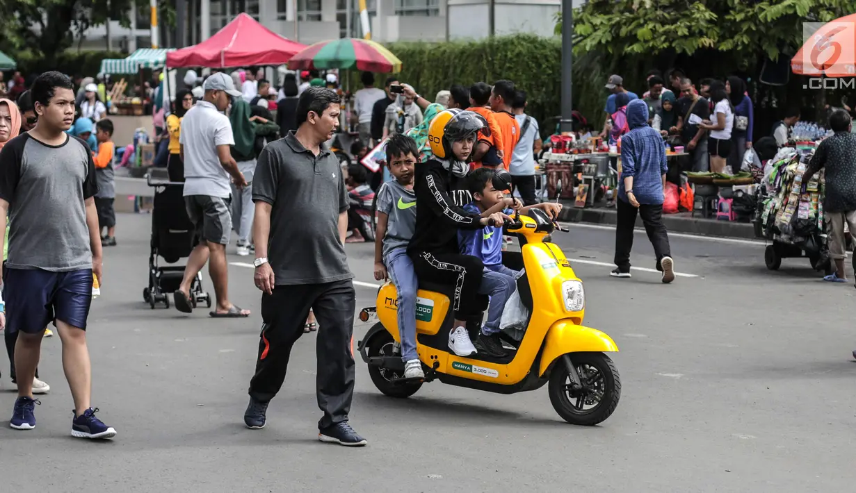 Pengendara sepeda motor listrik Migo saat melintasi CFD di kawasan Bundaran HI, Jakarta, Minggu (17/2). Petugas Dishub menghimbau penyewa untuk tidak melintasi jalan raya karena belum memenuhi uji layak operasi. (Liputan6.com/Faizal Fanani)