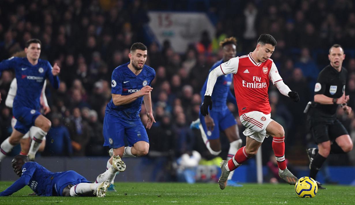 Striker Arsenal, Gabriel Martinelli, menggiring bola saat menghadapi Chelsea pada laga Premier League pekan ke-24 di Stamford Bridge, London, Rabu (22/1). Arsenal tahan imbang Chelsea 2-2. (AFP/Daniel Leal-Olivas)