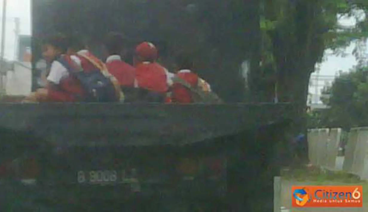 Anak-anak Sekolah Dasar (SD) naik mobil truk terbuka di Jalan Bekasi Timur, tepatnya depan penjara Cipinang. (Pengirim : Untung)