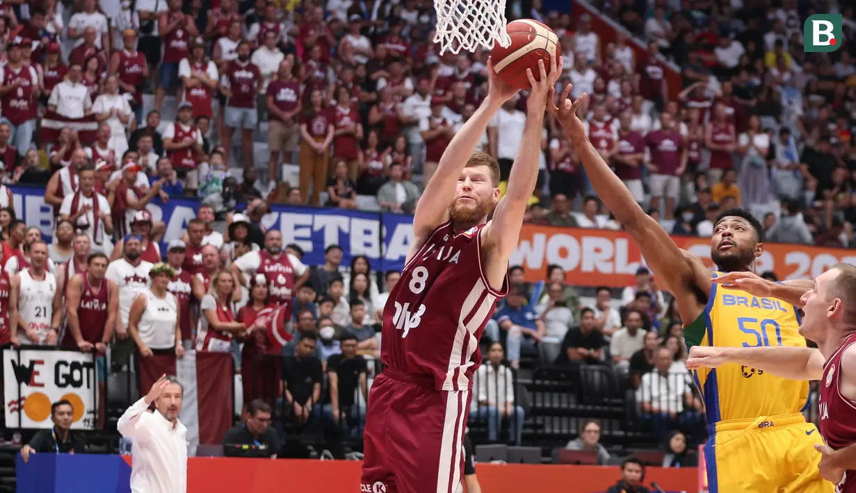 Pebasket Latvia, Davis Bertrans (kiri) berusaha menjangkau bola saat laga Grup L Piala Dunia FIBA 2023 melawan Brasil di Indonesia Arena, Senayan, Jakarta, Minggu (03/09/2023). Latvia menang dengan skor 104-84. (Bola.com/Bagaskara Lazuardi)