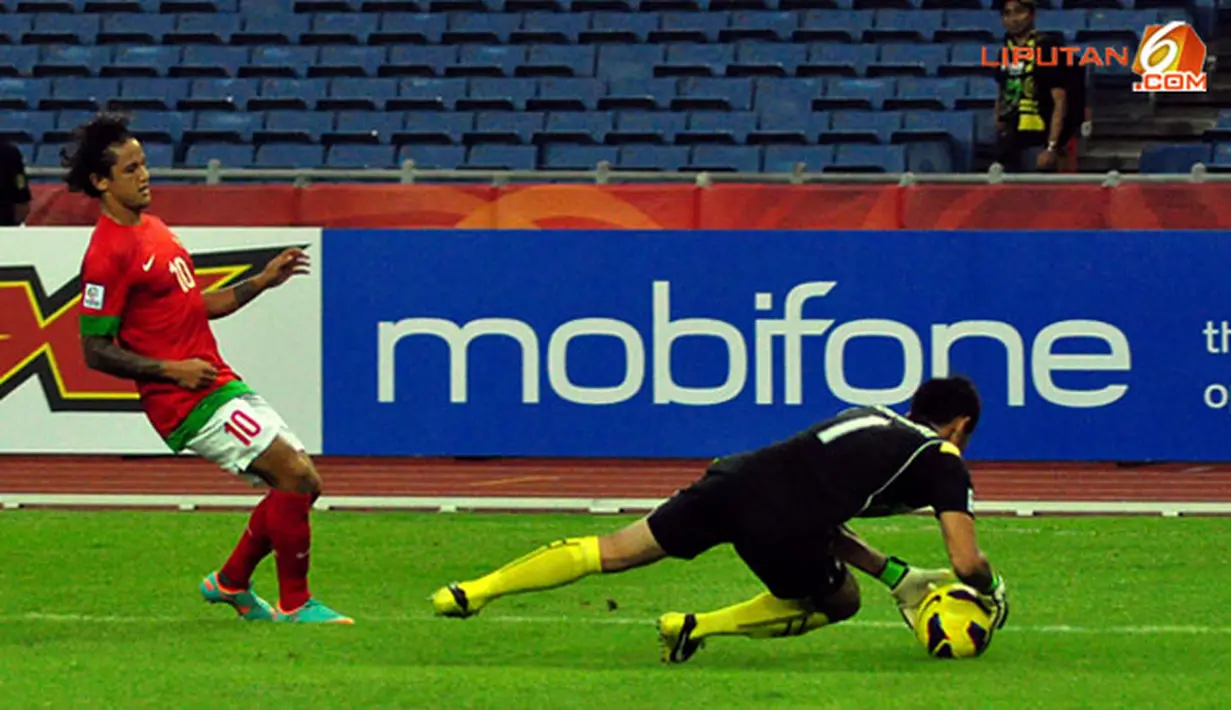 Pemain depan Timnas Indonesia, Irfan Bachdim berhadapan dengan kiper Laos Sengphachan Bounthisanh dalam laga Piala AFF Suzuki 2012, di Stadion Bukit Jalil, Kuala Lumpur, Malaysia. Kamis, 25/11/2012. Pertandingan Berakhir seri 2-2.