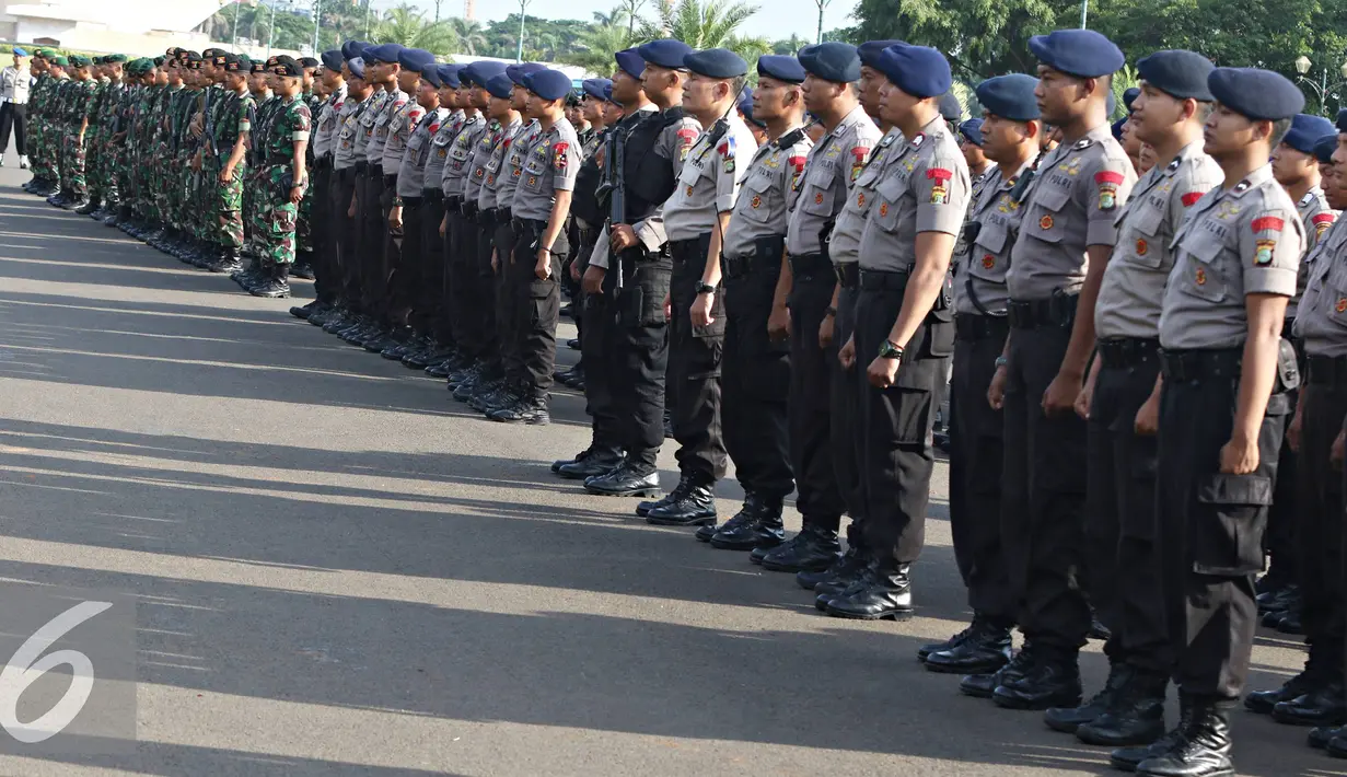 Petugas mengikuti apel gabungan di Monas, Jakarta, Kamis (31/12). Sebanyak 1300 personel gabungan yang terdiri dari polisi, TNI, Pol PP, dan Pramuka dikerahkan untuk mengamankan perayaan malam tahun baru. (Liputan6.com/Immanuel Antonius)