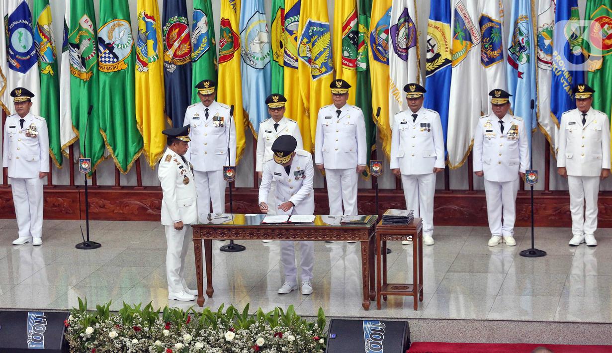 Menteri Dalam Negeri (Mendagri) Tito Karnavian (tengah kiri) menyaksikan penandatanganan dokumen saat pelantikan sembilan Penjabat (Pj) Gubernur di Kantor Kementerian Dalam Negeri, Jakarta, Selasa (5/9/2023). Hal itu dalam rangka menggantikan para Guburnur yang telah habis masa jabatannya pada 5 September 2023. (Liputan6.com/Angga Yuniar)