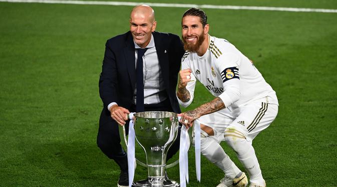 Pelatih Real Madrid, Zinedine Zidane, dan Sergio Ramos merayakan juara La Liga usai timnya mengalahkan Villreal pada laga lanjutan pekan ke-37 di Estadio Alfredo Di Stefano, Jumat (17/7/2020) dini hari WIB. (AFP/Gabriel Bouys)