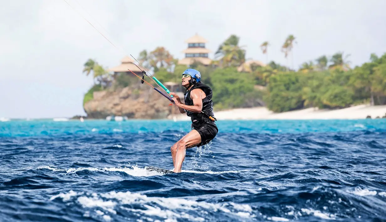 Aksi Barack Obama saat menaiki kite surfing di Kepulauan Karibia, Selasa (7/2). Obama dijamu oleh miliarder Richard Branson saat berlibur di Karibia. (AP/Jack Brockway)