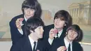 Personil The Beatles George Harrison, Paul McCartney, John Lennon dan Ringo Starr menunjukkan medali yang diberikan Ratu Elizabeth II dalam sebuah upacara di Istana Buckingham di London, Inggris pada 26 Oktober 1965. (AP Photo, File)