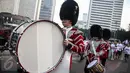 Scotts Guard alias penjaga Buckingham Palace melakukan aksi mengelilingi di Bundaran HI, Jakarta, Minggu (5/6). Aksi Scotts Guard yang didatangkan dari Inggris ini dalam rangka hari ulang tahun Ratu Elizabeth II yang ke-90. (Liputan6.com/Faizal Fanani)