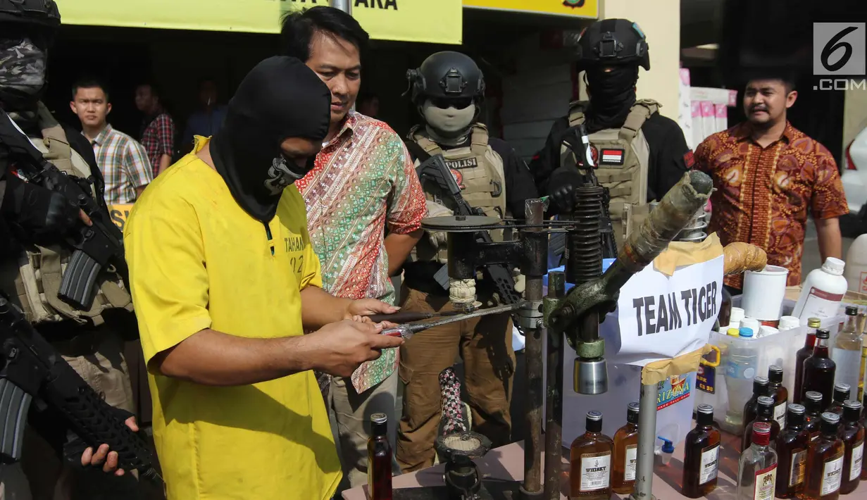 Tersangka dihadirkan saat rilis razia miras di Polres Metro Jakarta Utara, Jumat (6/4). Petugas juga menyita 1 buah tangki air tempat alkohol, 2 buah jerigen berisi alkohol, label miras, dan bahan-bahan untuk pembuatan miras. (Liputan6.com/Arya Manggala)
