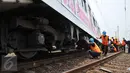 Sejumlah Petugas saat mengevakuasi gerbong kereta yang anjlok di jalur kereta api manggarai, Jakarta, Selasa (27/10/2015). Belum diketahui sebab Kereta anjlok tersebut. (Liputan6.com/Gempur M Surya)