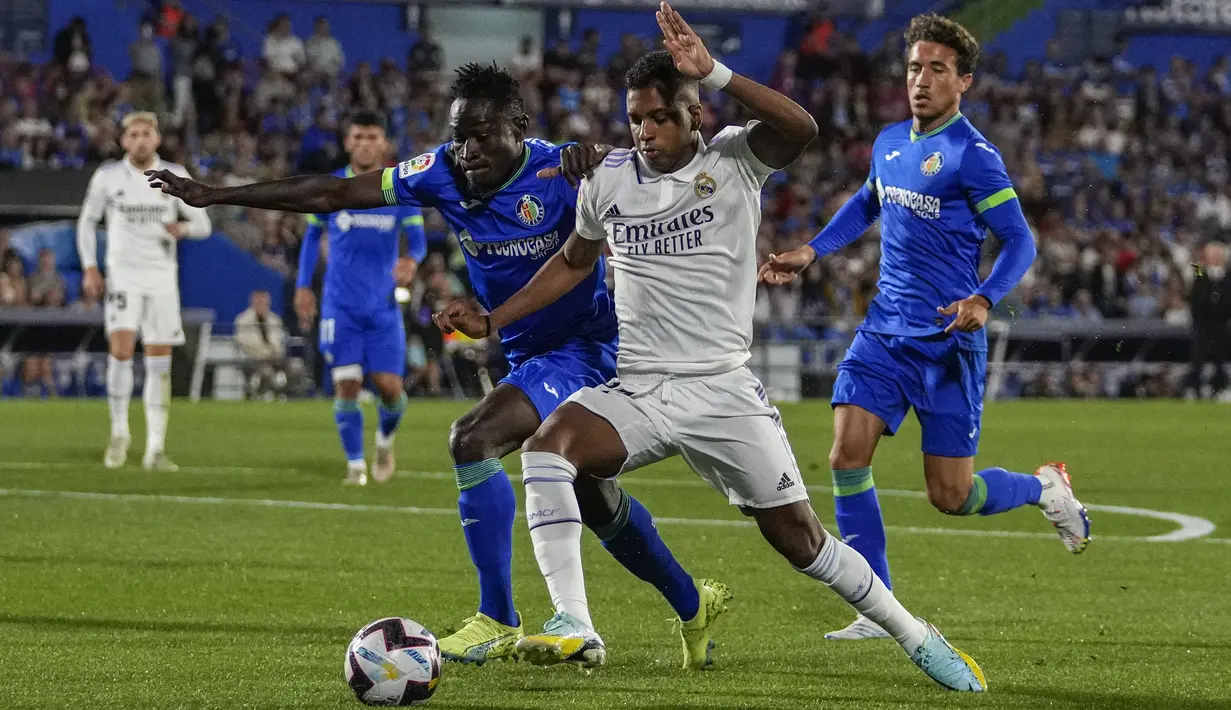 Penyerang Real Madrid Rodrygo berebut bola dengan bek Getafe Djene Dakonam pada pekan delapan La Liga musim 2022/2023 di Stadion Coliseum Alfonso Perez, Minggu (9/10/2022) dini hari WIB. Kemenangan itu mengukuhkan Los Blancos (julukan Real Madrid) yang tak terkalahkan dalam 8 pertandingan di Liga Spanyol 2022-2023. (AP Photo/Bernat Armangue)