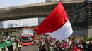 Bus yang ditumpangi Timnas Indonesia U-22 melewati pusat Flyover Karet saat pawai kontingen Indonesia untuk SEA Games 2023 yang bertajuk Kira87uara yang berlangsung di Jakarta, Jumat (19/05/2023). (Bola.com/Bagaskara Lazuardi)