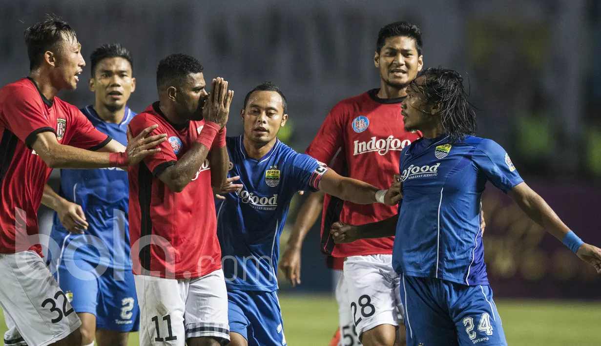 Gelandang Bali United, Yabes Roni, tampak meminta maaf saat dikejar gelandang Persib Bandung, Hariono. Hingga kini tidak diketahui apa motif Yabes Roni menendang bola secara keras ke arah Michael Essien. (Bola.com/Vitalis Yogi Trisna)